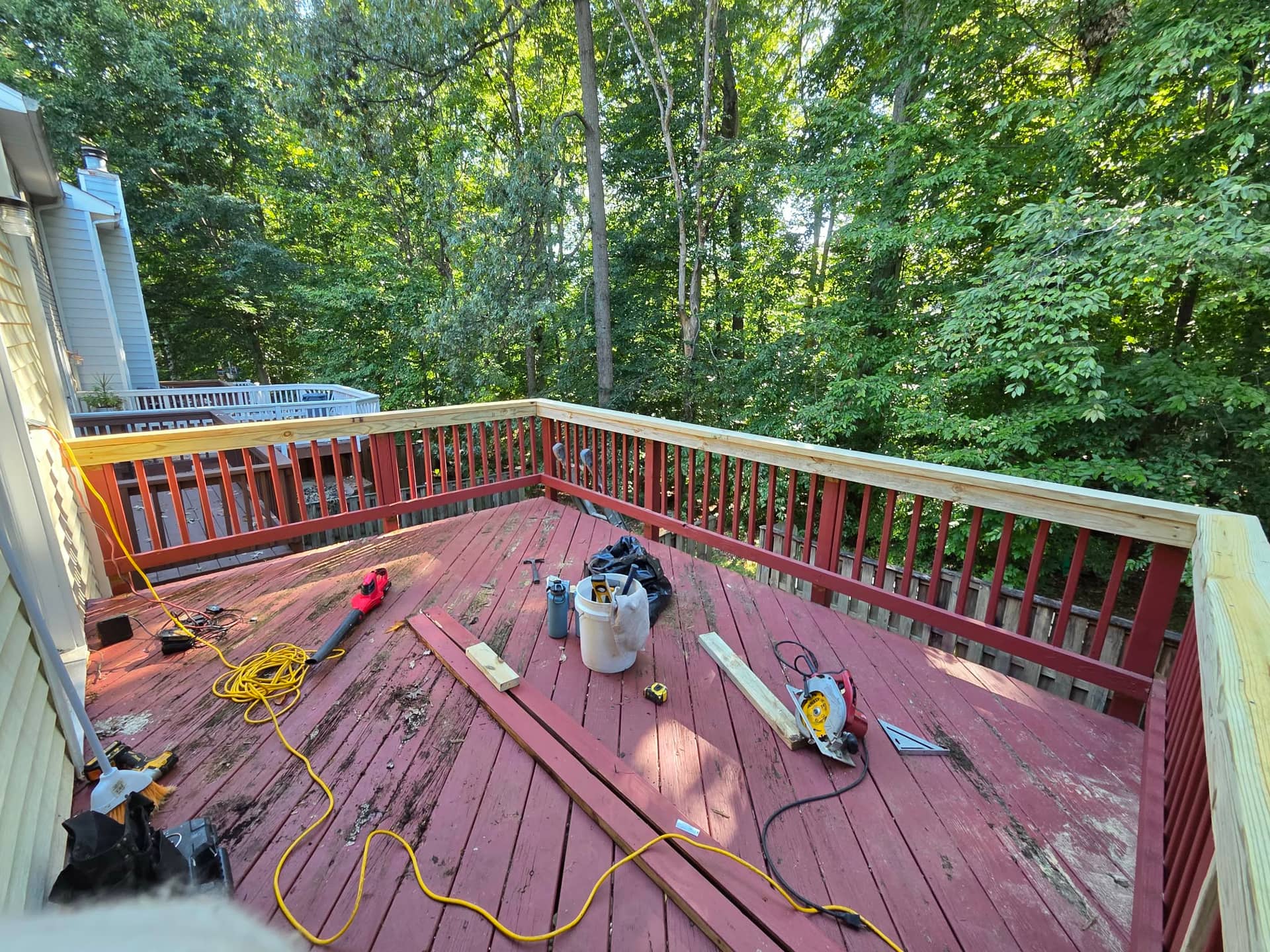 Wide view of replacement top rails with tools on the existing deck boards.