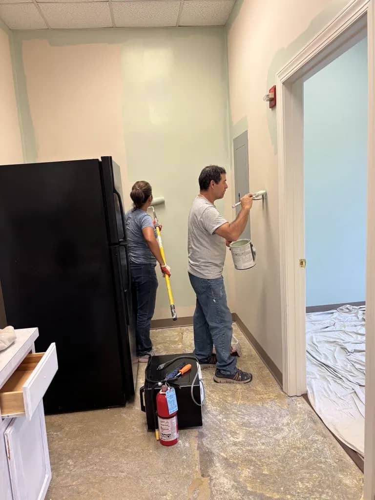 Melvin and team member rolling paint on interior walls